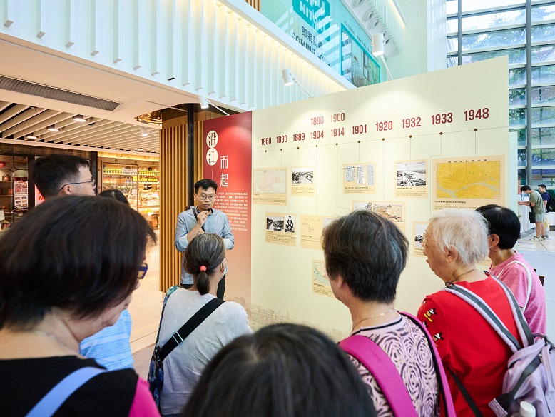 A guide explains the historical development of Changdi to the engaged visitors.