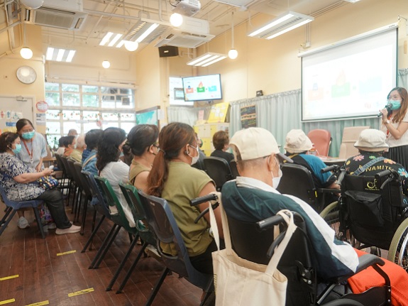 Dozens of elderly participants and their carers listen attentively to a presentation on the health benefits and appeal of soft meals.