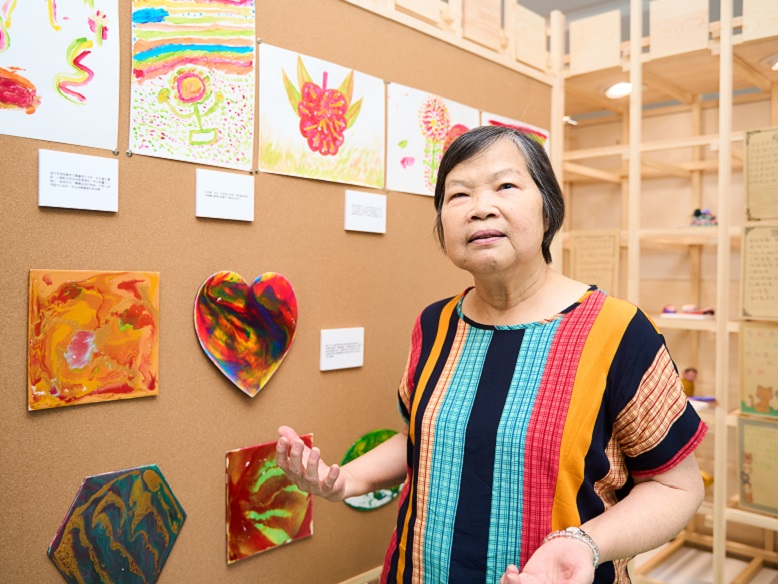 Ho Shuk-ying poses for a photo with her artwork.