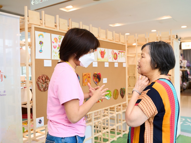 Ho Shuk-ying shares her experiences with an exhibition visitor.