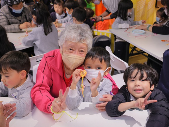 Chiu Kam-lin poses for a photo with children after together making an auspicious knot for the Lunar New Year.
