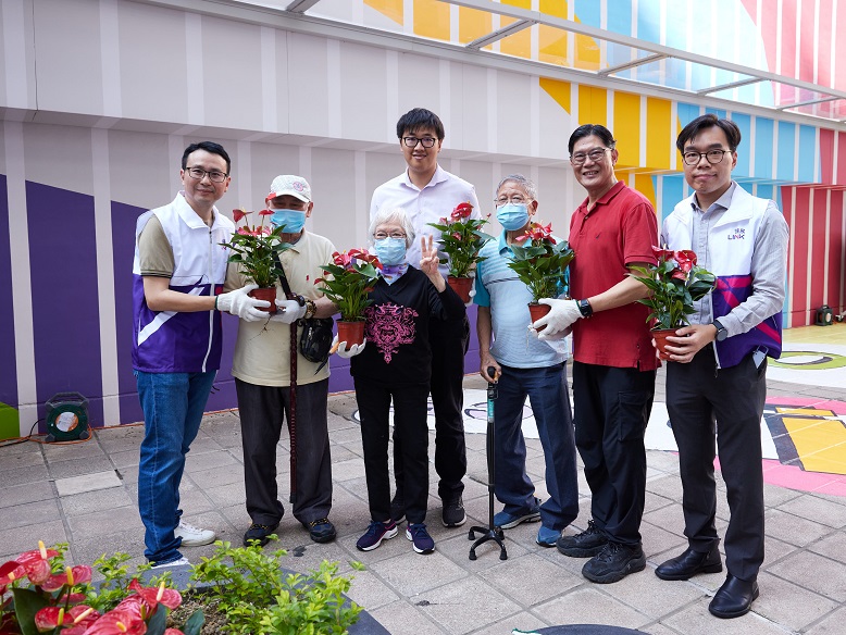 Chung Kin-fung and Tuen Mun District Councillor, Tsui Fan (second from the right), plant flowers alongside the elderly.