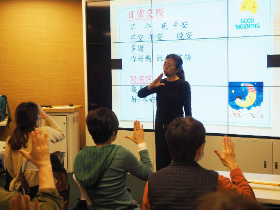 A sign language instructor teaching participants common signs for daily interactions.