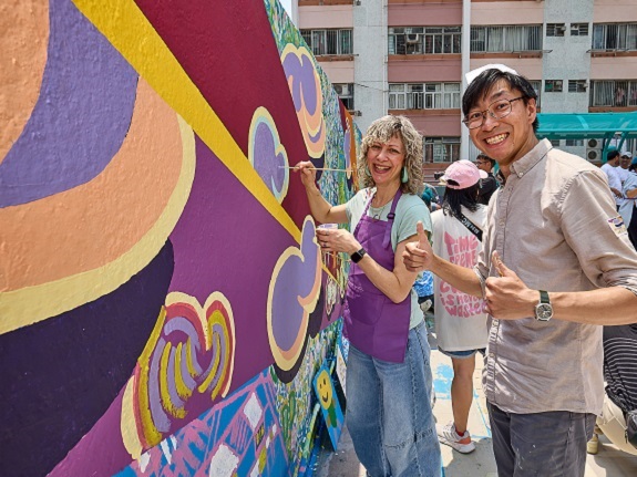Artist Sidney Cai (right), who excels in landscape design and urban sketching, teams up with volunteers on a mural.