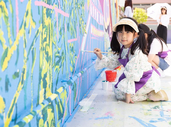 Children showcase their artistic talents during mural creation.