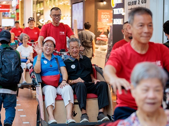 Lim enjoying her trishaw ride in Jurong Point, along with other seniors.