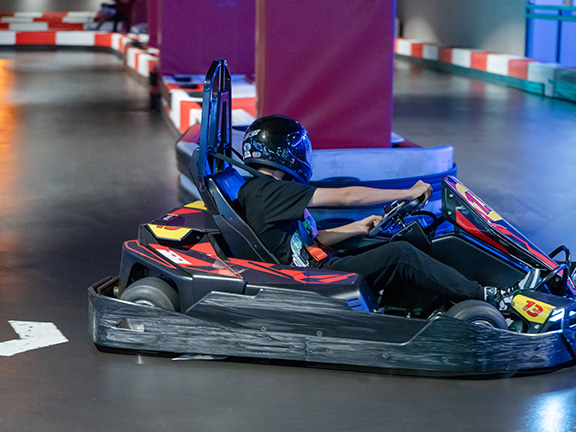 Hong Kong’s largest indoor go-karting venue – 18 Challenge Karting.  The spacious area is illuminated in blue while the racetracks are bordered with red and white protective barriers.