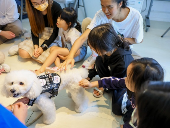 義工與SEN孩童與治療犬互動。